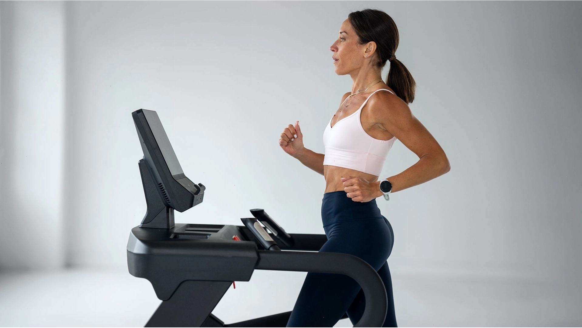 Ba người tập luyện trên các loại máy cardio khác nhau trong phòng gym