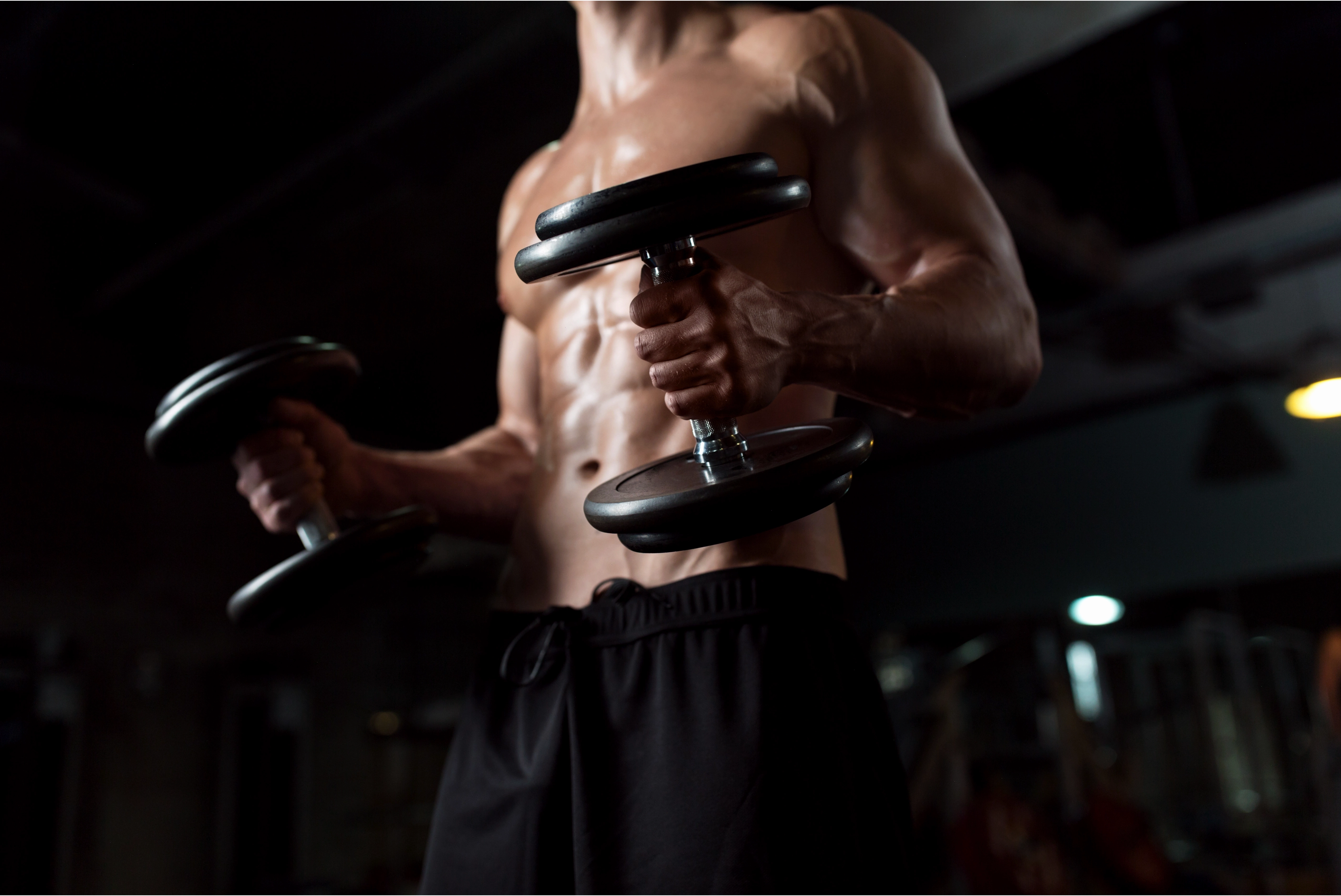 Cận cảnh một người đàn ông trong phòng gym cầm bình lắc thực phẩm bổ sung