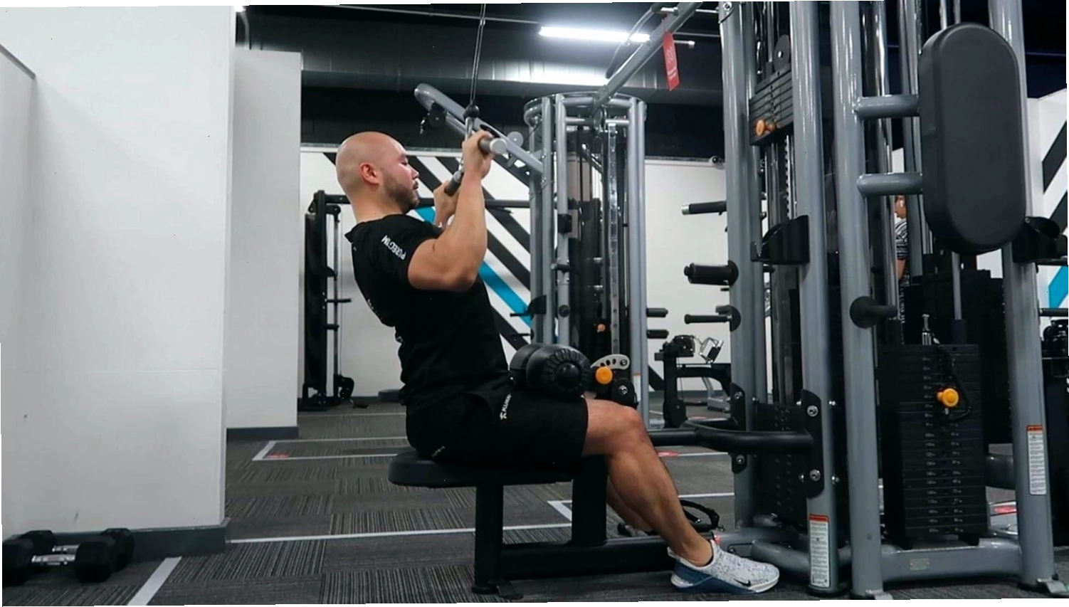 Hình ảnh minh họa người đang thực hiện bài tập machine lat pulldown cơ bản