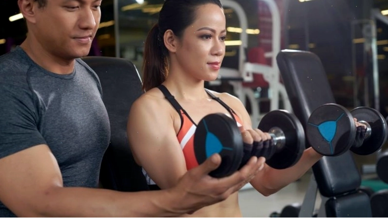 Huấn luyện viên gym tạo động lực cho học viên trong buổi tập