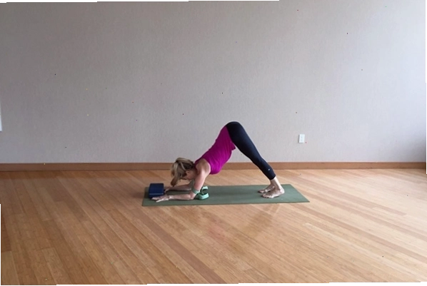 Khối yoga đặt giữa hai bàn tay khi chuẩn bị vào tư thế Chống tay Cẳng tay