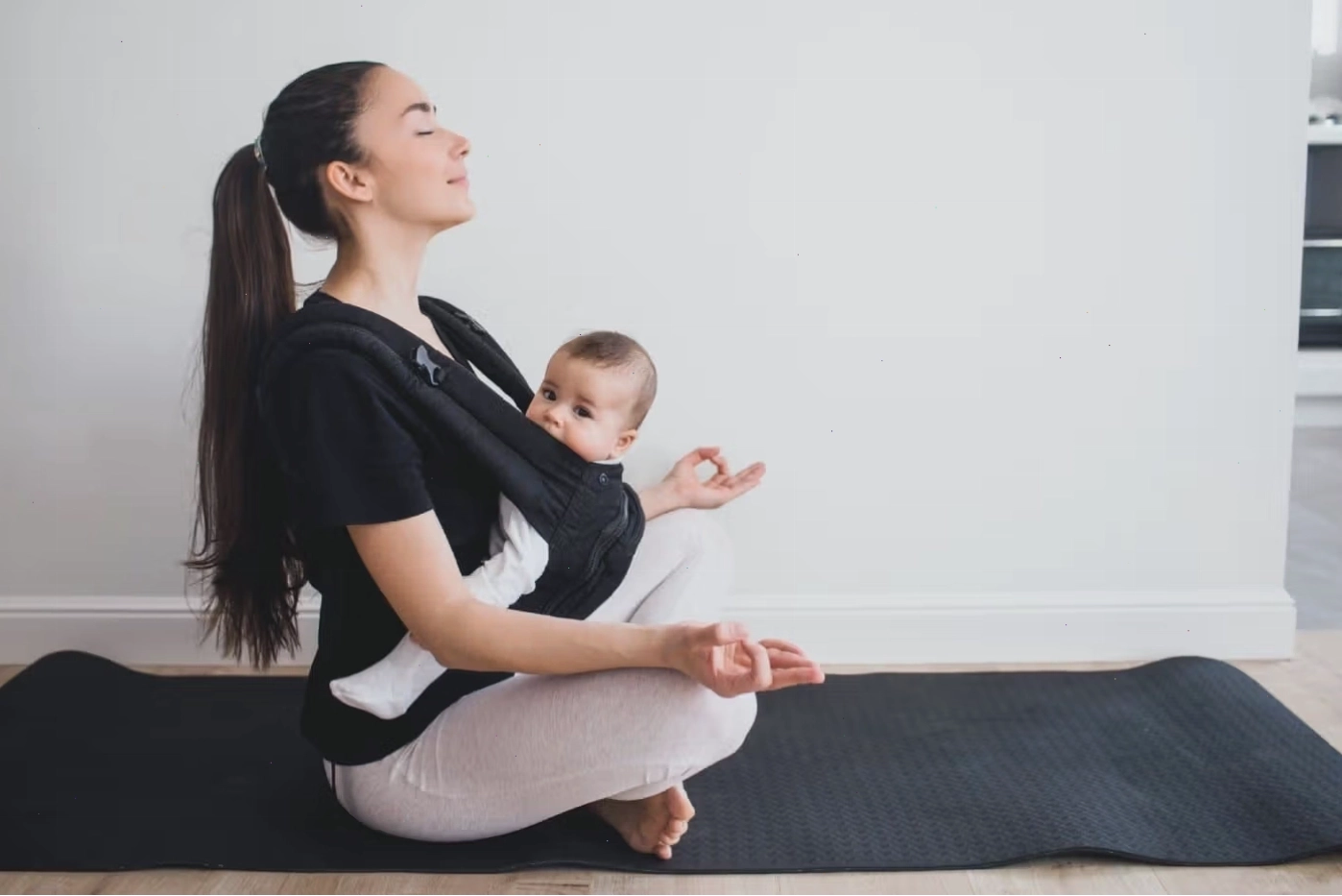 Mẹ thực hành yoga khi đang địu em bé