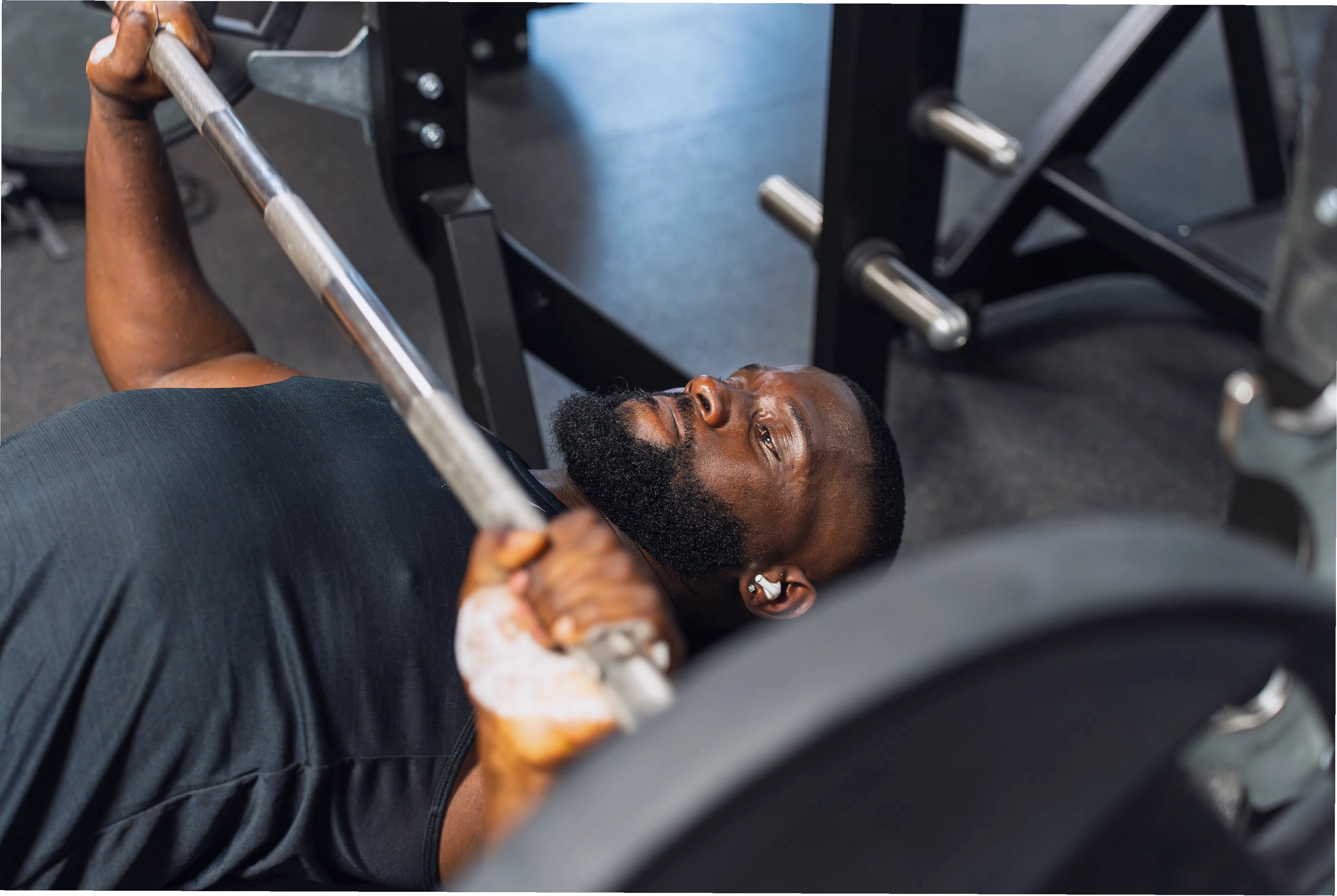 Nam giới tập luyện bài barbell bench press trong phòng gym