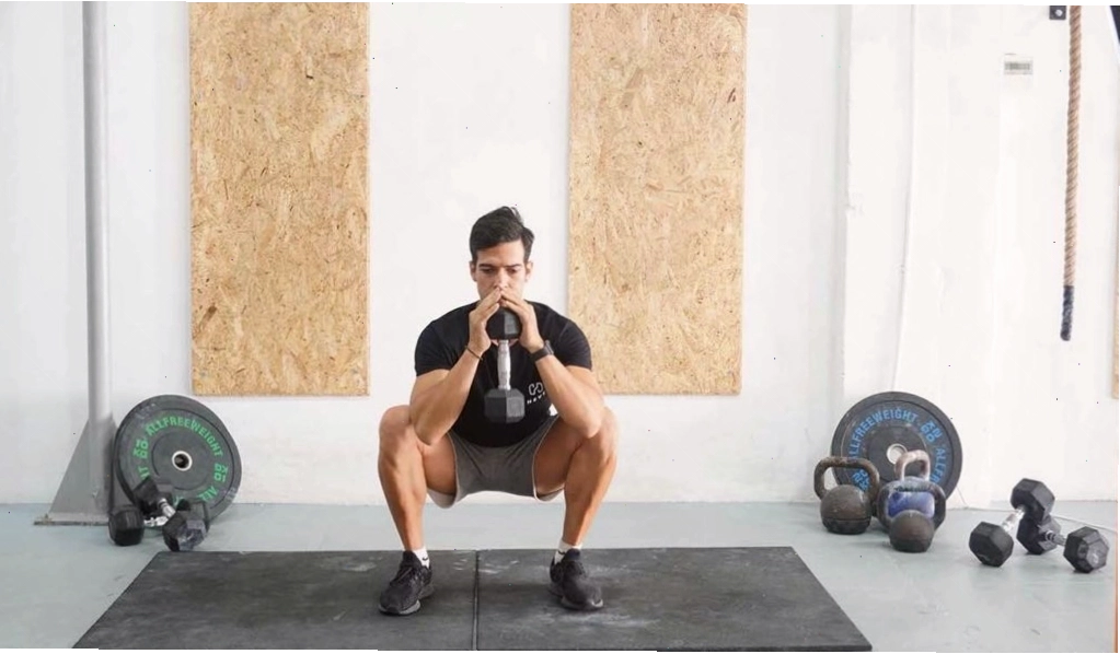 Nam giới thực hiện động tác Goblet Squat với tạ đơn