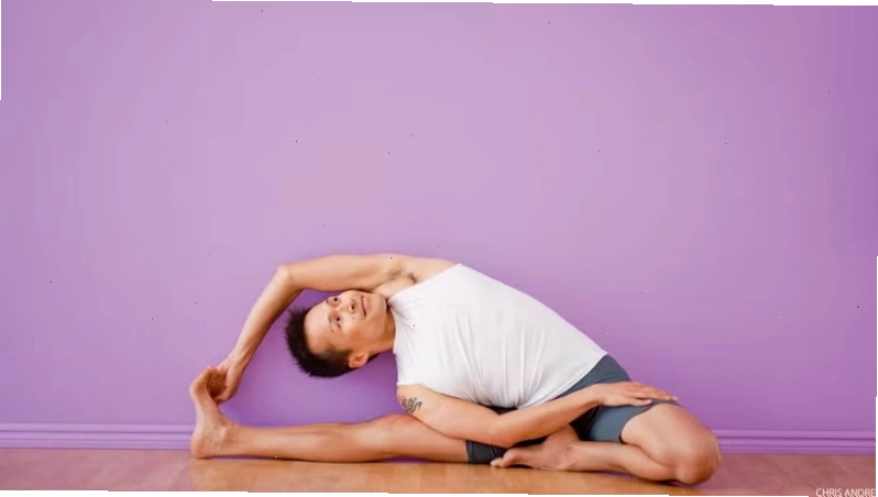 Nam giới thực hiện động tác vặn mình bên tường màu tím trong yoga