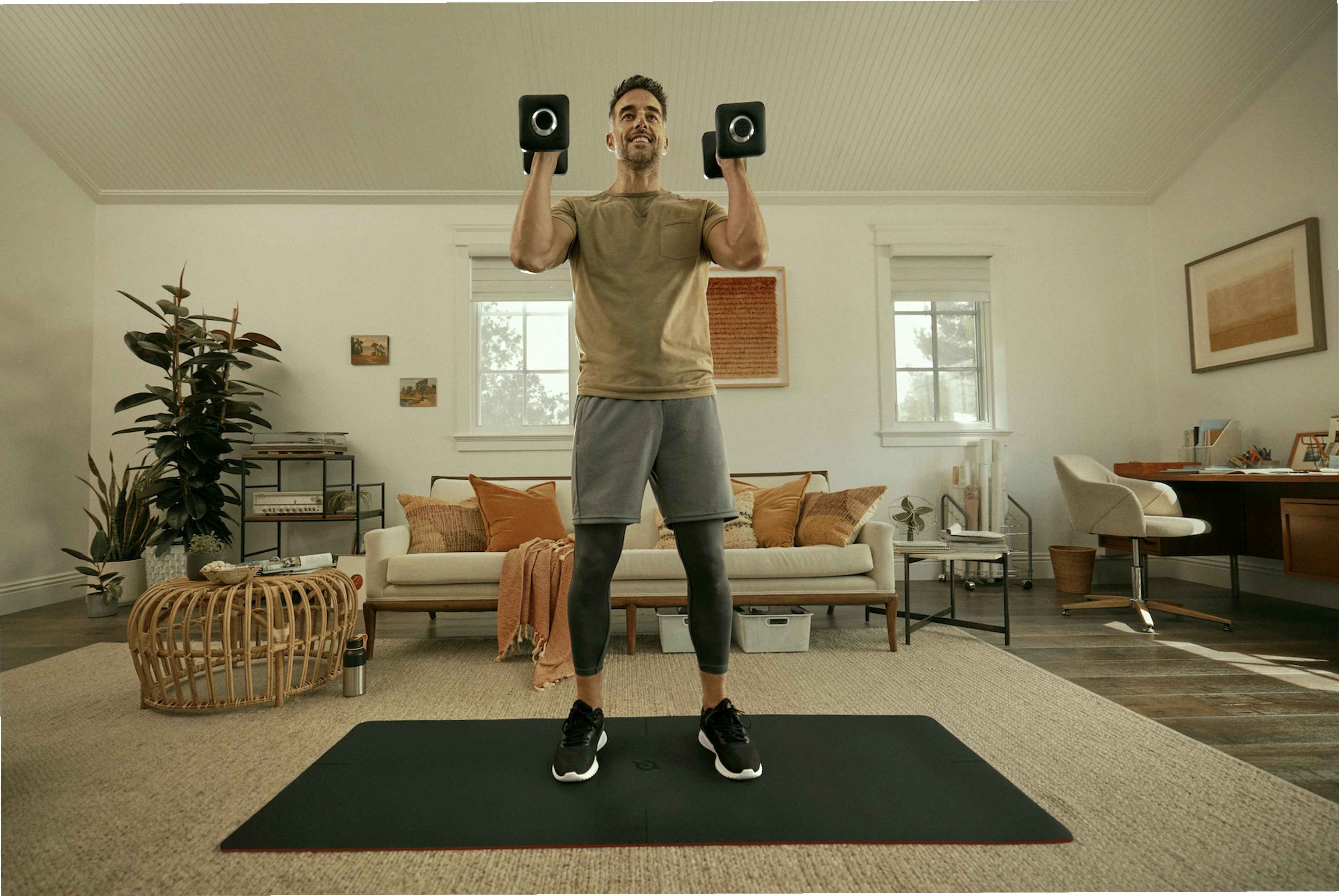Người đàn ông tập bài tập Hamstring với tạ đôi