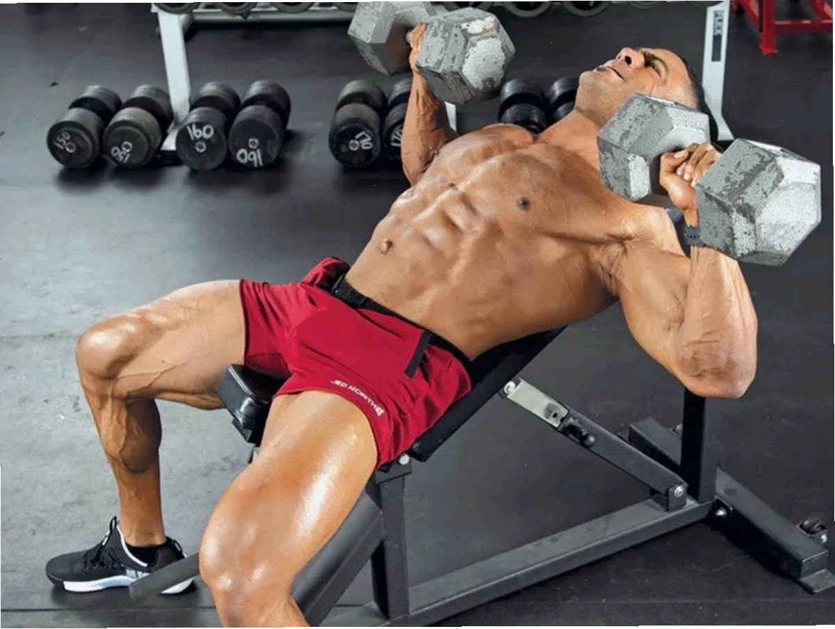 Người đàn ông thực hiện bài tập Standard Dumbbell Chest Press trên ghế phẳng
