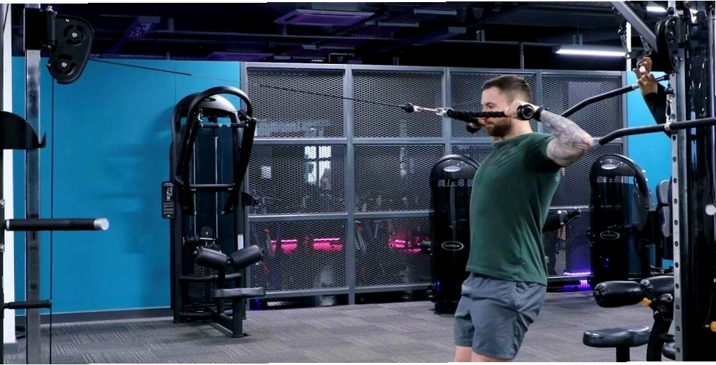 Người tập thực hiện bài tập seated face pull trên máy kéo cáp