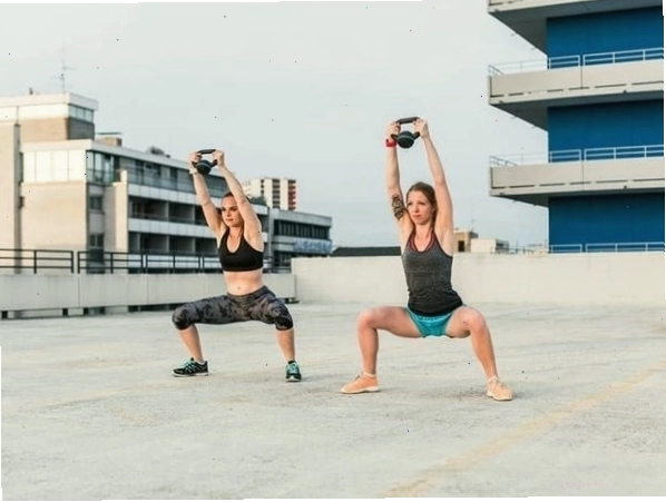 Người tập thực hiện động tác Overhead Squat với tạ ấm