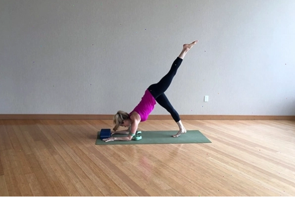 Người tập thực hiện tư thế Chống tay Cẳng tay (forearm stand) trên thảm yoga