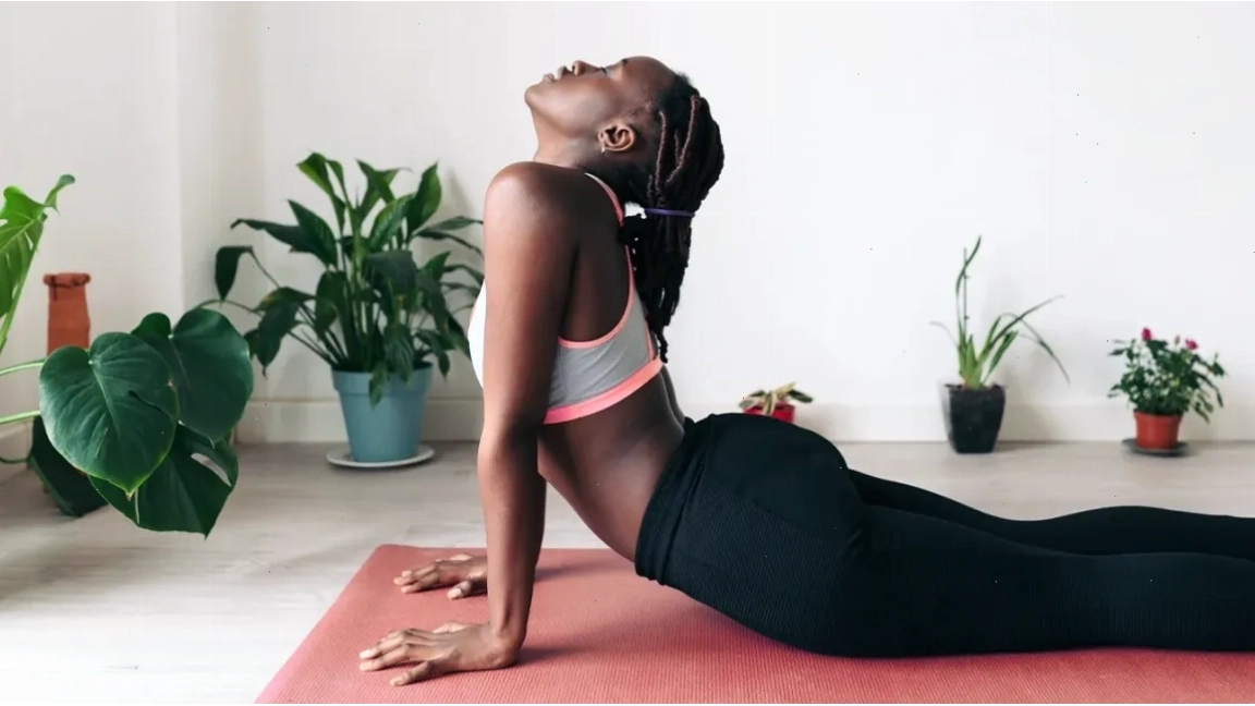 Phụ nữ da đen giữ tư thế rắn hổ mang trong yoga