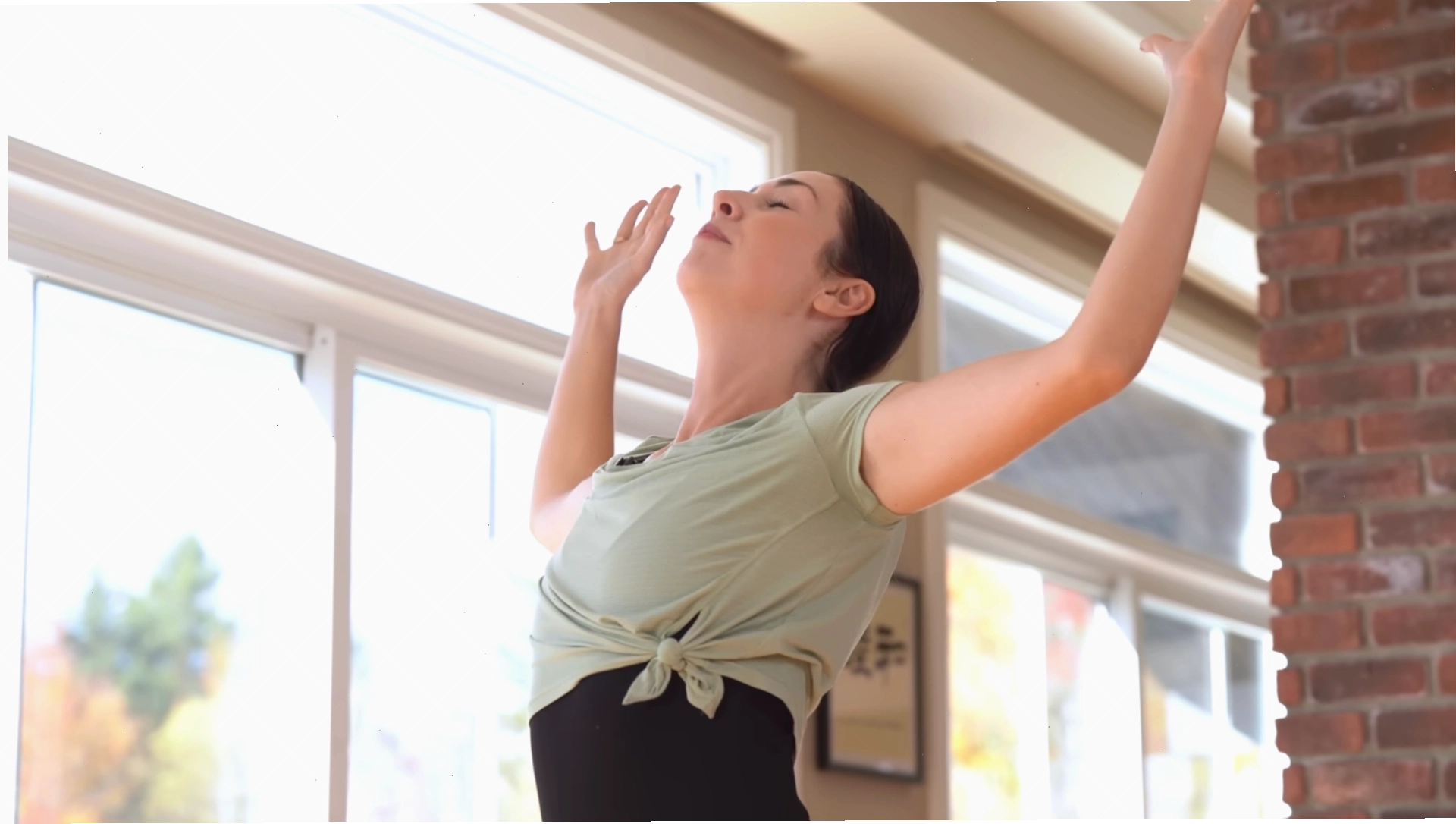 Phụ nữ đứng trong tư thế Chào mặt trời (Sun Salutation) trong buổi tập yoga sáng