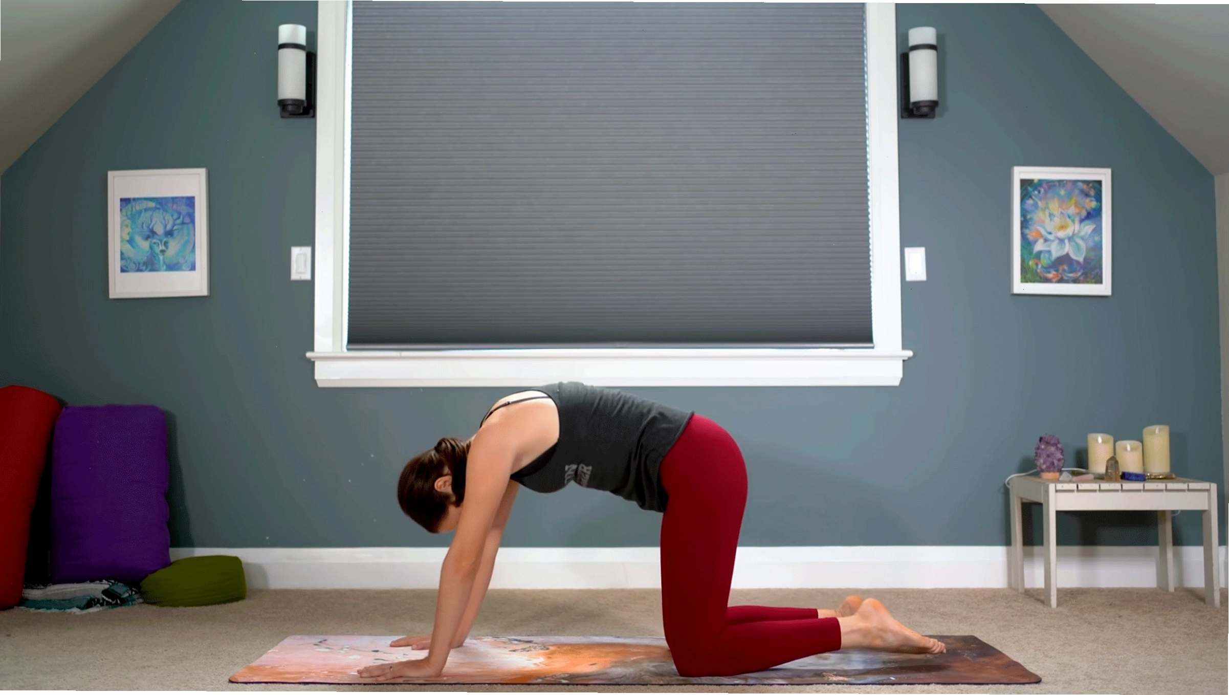 Phụ nữ thực hành tư thế Mèo trên thảm tập yoga