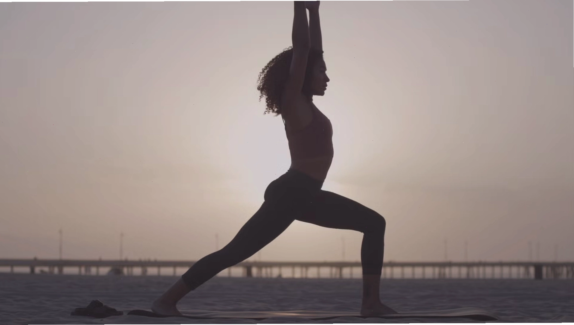Phụ nữ thực hiện động tác Hít thở sâu trong tư thế Trẻ em (Child’s Pose) để khởi đầu buổi tập yoga sáng