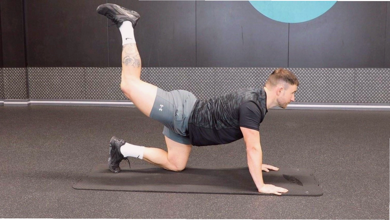 PT demonstrating how to do donkey kicks